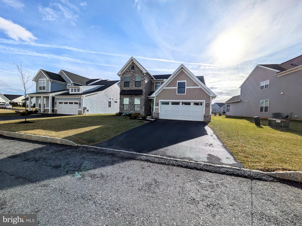 view of front facade with cooling unit, a garage, and a front yard