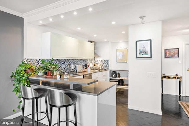 kitchen featuring kitchen peninsula, appliances with stainless steel finishes, dark tile patterned floors, and a breakfast bar area