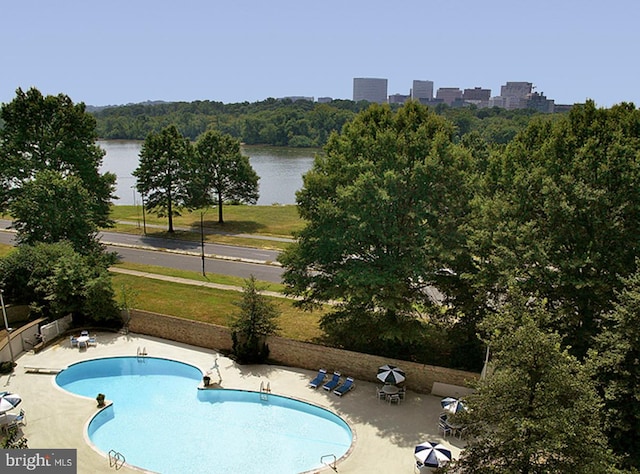 view of swimming pool with a patio and a water view