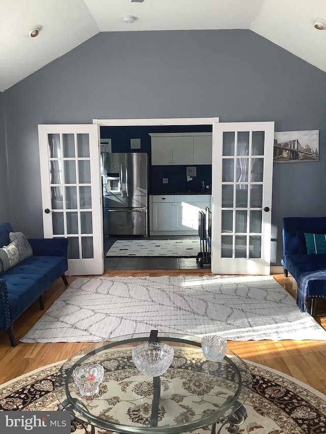 living room featuring french doors, hardwood / wood-style floors, and vaulted ceiling