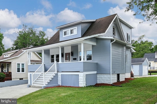 view of front of house with an outbuilding, a front lawn, and covered porch