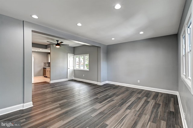 unfurnished living room featuring dark hardwood / wood-style flooring and ceiling fan