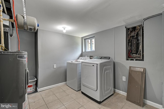 laundry area featuring light tile patterned flooring, electric water heater, and separate washer and dryer