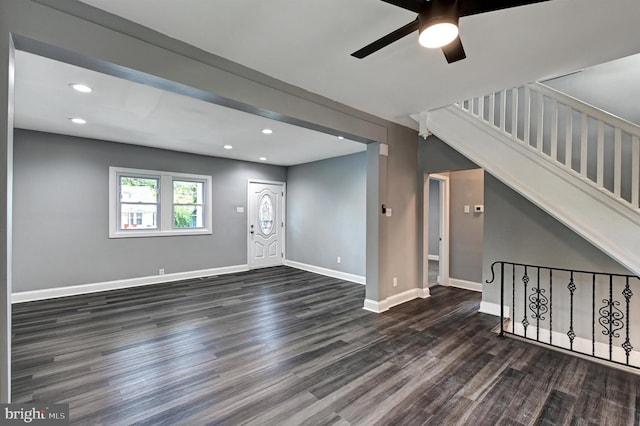 unfurnished living room with dark hardwood / wood-style flooring and ceiling fan