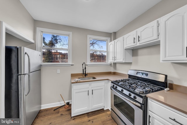 kitchen with white cabinets, appliances with stainless steel finishes, dark hardwood / wood-style flooring, and sink