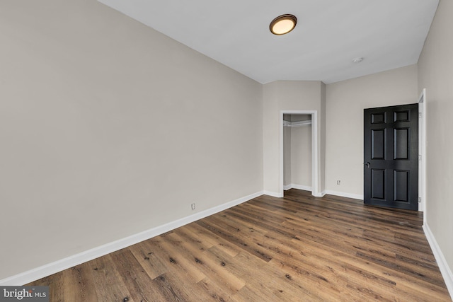 unfurnished bedroom with a closet and dark wood-type flooring