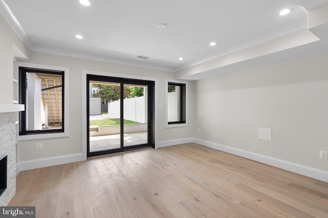 3710 S St NW, Washington, DC 20007 - unfurnished living room featuring baseboards, crown molding, a stone fireplace, and light wood-style floors