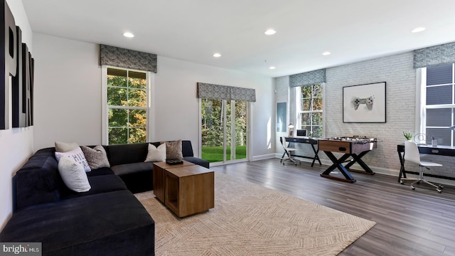 living room with light wood-type flooring and brick wall