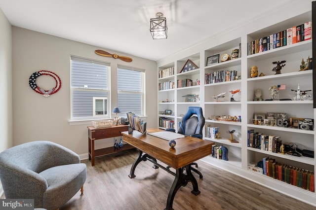 office space with built in features and wood-type flooring