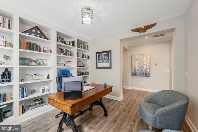 home office featuring wood-type flooring and built in features