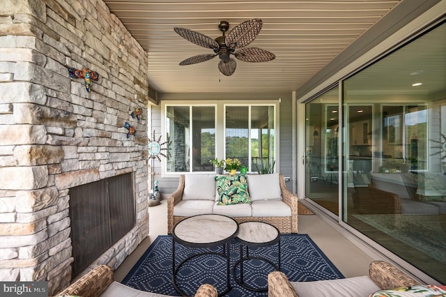 view of patio with an outdoor living space with a fireplace and ceiling fan