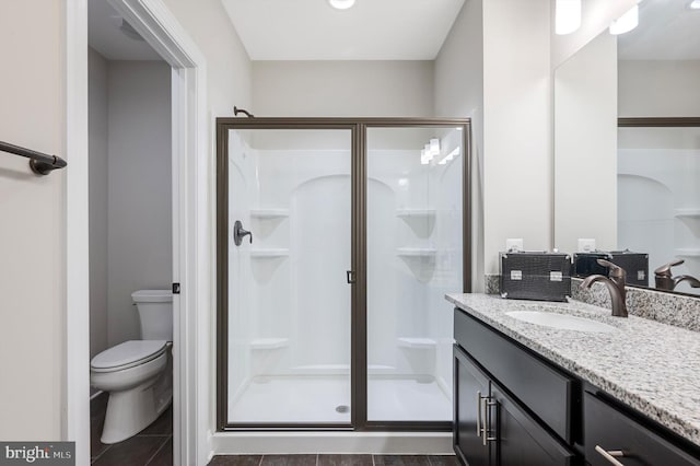 bathroom featuring vanity, toilet, and a shower with door