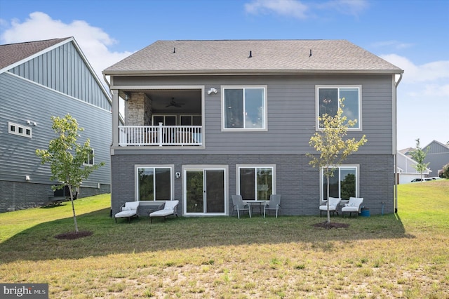 back of property with a lawn and a balcony