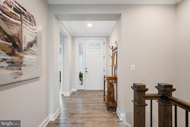 entryway featuring ornamental molding and light hardwood / wood-style flooring