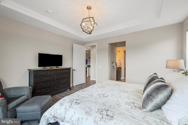 bedroom with dark hardwood / wood-style flooring, an inviting chandelier, a raised ceiling, and crown molding