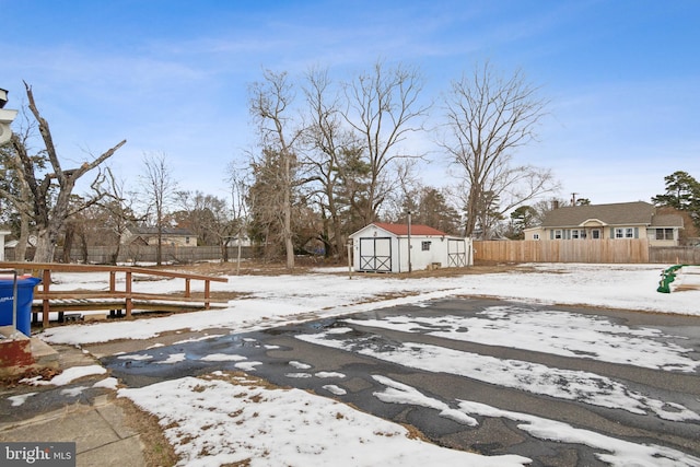 yard layered in snow with a storage unit