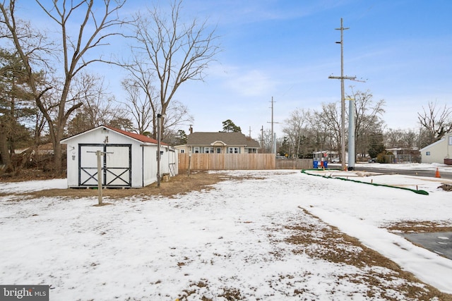 yard covered in snow with a storage shed