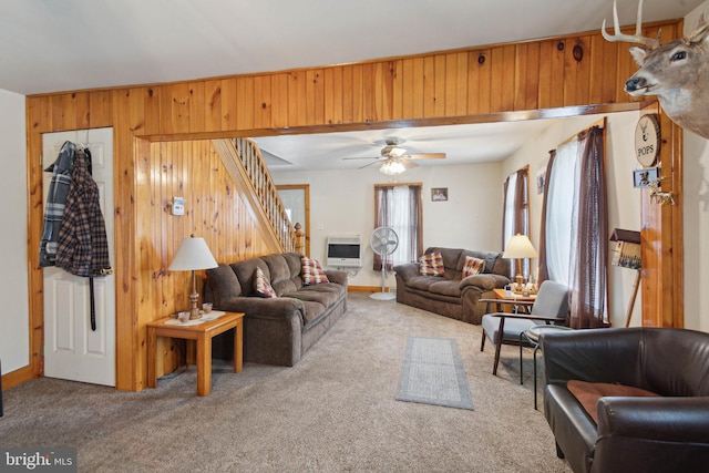 living room featuring ceiling fan, wooden walls, heating unit, and carpet