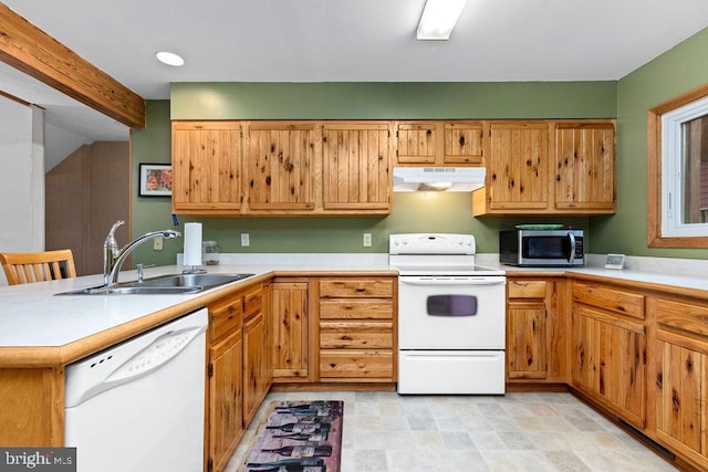 kitchen featuring kitchen peninsula, white appliances, sink, and a breakfast bar