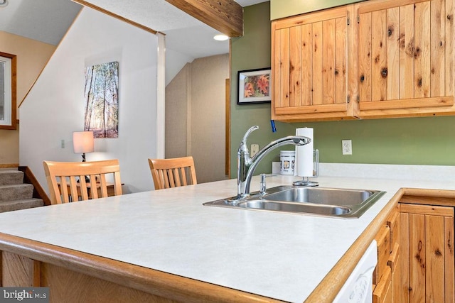 kitchen featuring beam ceiling, dishwasher, and sink