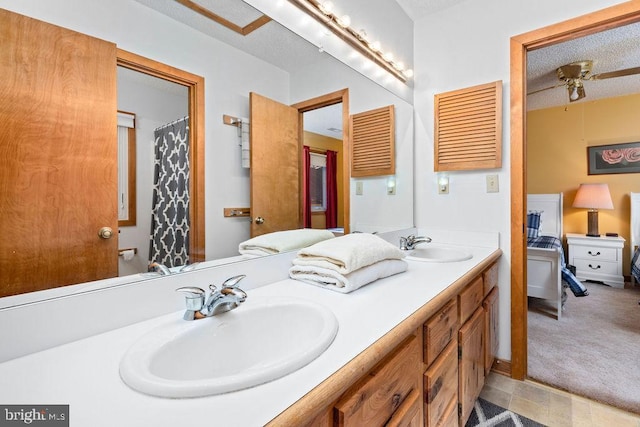 bathroom featuring ceiling fan, vanity, and a textured ceiling