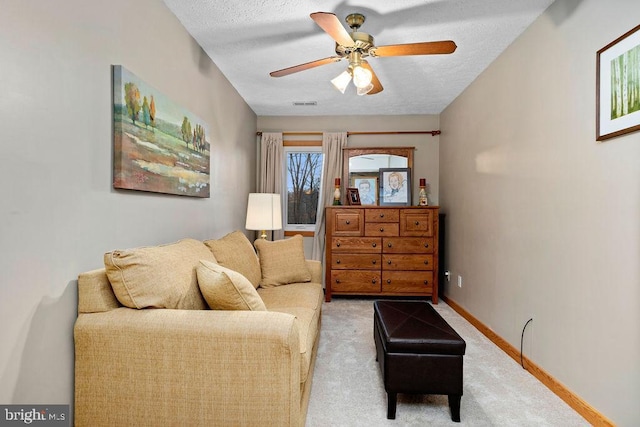 living room with carpet flooring, ceiling fan, and a textured ceiling