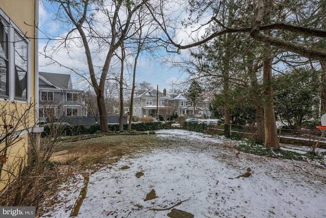 snowy yard featuring a residential view