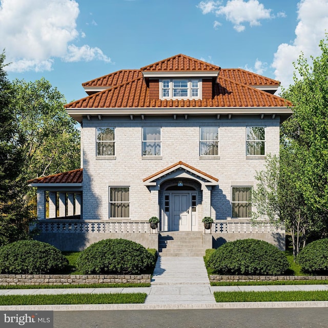 view of front of home with a tiled roof and brick siding