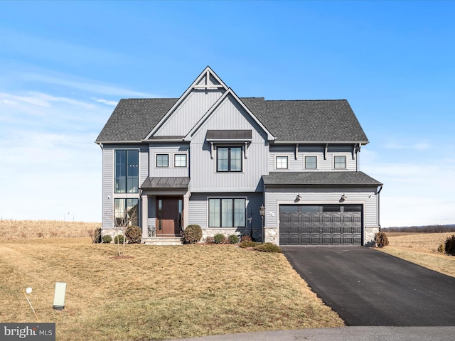 view of front of home featuring driveway, stone siding, a garage, and roof with shingles