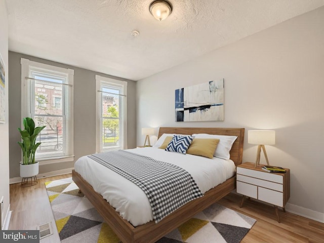 bedroom featuring wood-type flooring and a textured ceiling