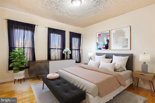 bedroom featuring hardwood / wood-style flooring and a textured ceiling