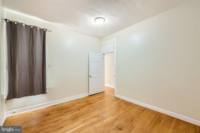 spare room with wood-type flooring and a textured ceiling