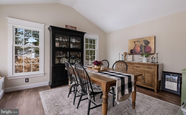 dining area with vaulted ceiling and hardwood / wood-style flooring