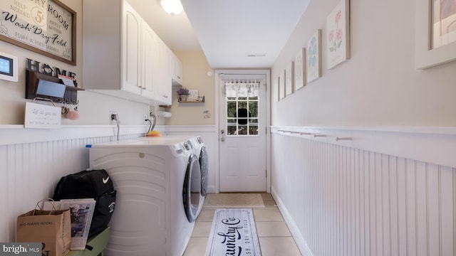 laundry area featuring light tile patterned floors, independent washer and dryer, and cabinets