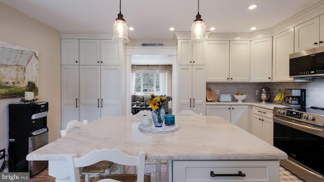 kitchen featuring a kitchen bar, a center island, pendant lighting, and stainless steel range with electric stovetop