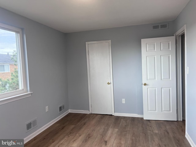 unfurnished bedroom with dark wood-type flooring