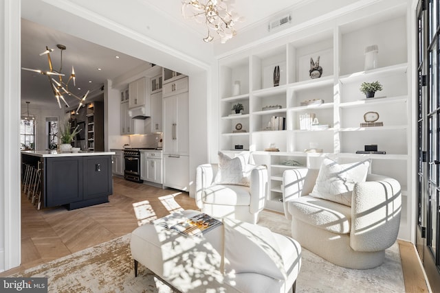 living room featuring crown molding, parquet floors, a chandelier, and built in features