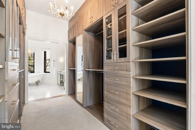 walk in closet featuring dark carpet and an inviting chandelier