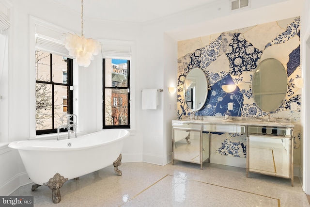 bathroom with vanity, a chandelier, and a bathing tub