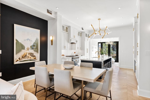 dining area featuring a notable chandelier, sink, light parquet flooring, and french doors