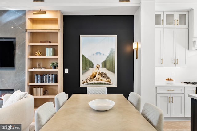 dining space featuring radiator, built in features, and light hardwood / wood-style floors