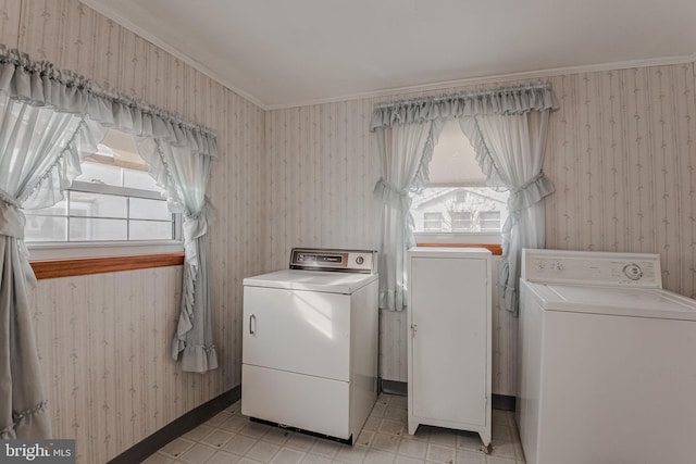 clothes washing area with separate washer and dryer and crown molding