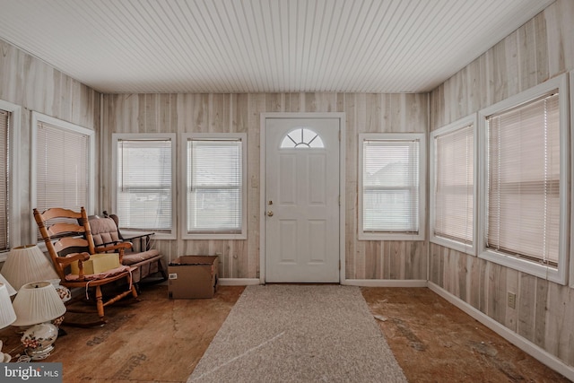 entrance foyer with wood walls and concrete flooring