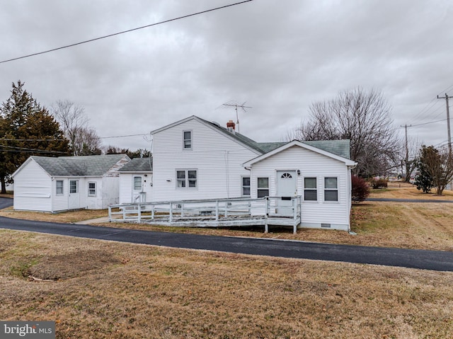 view of front of house featuring a wooden deck and a front lawn