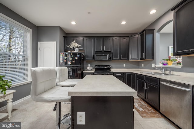 kitchen featuring sink, a center island, black appliances, and light tile patterned floors