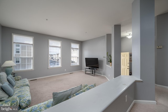 living room featuring light carpet and plenty of natural light