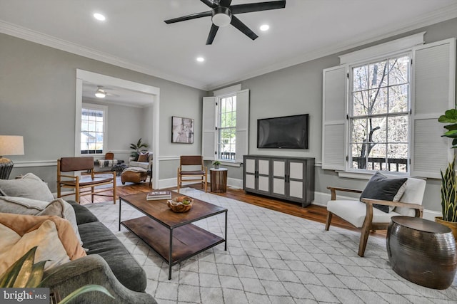 living room with light hardwood / wood-style flooring, ceiling fan, and ornamental molding