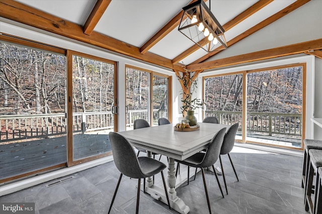 sunroom / solarium featuring lofted ceiling with beams