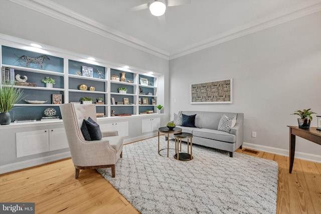 living room featuring hardwood / wood-style flooring, ceiling fan, and crown molding