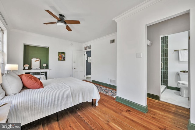 bedroom with ceiling fan, wood-type flooring, crown molding, and connected bathroom